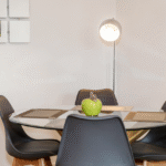 Modern dining area with table set for four and hanging lamp at The Amber Suite, Centrium, Woking