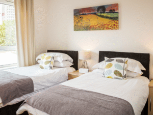 Bright twin bedroom with contemporary bedding and window view at The Amber Suite, Centrium, Woking