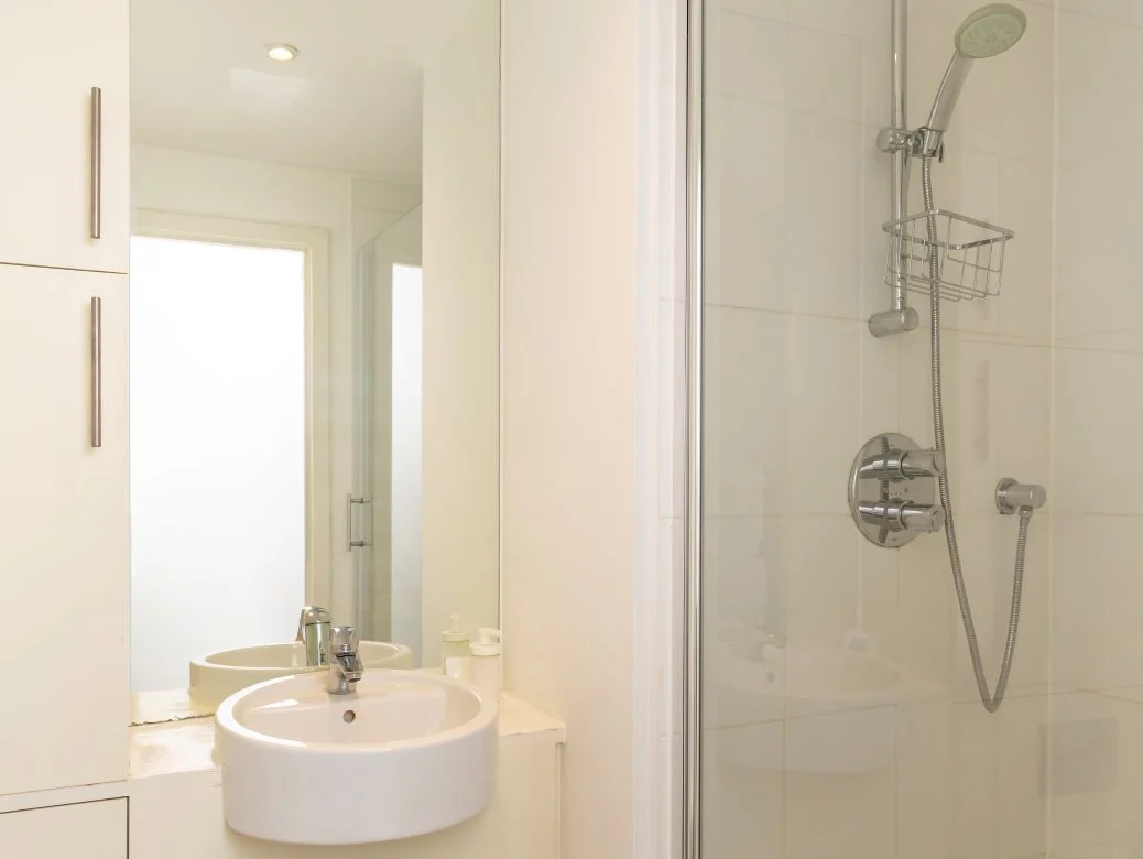 Ensuite bathroom with walk-in shower, glass screen, and wall mirror at The Sycamore Suite, Enterprise Place, Woking