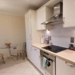 Fully equipped open-plan kitchen with oven, hob, and dining nook at The Elm Suite, Kings Road, Reading