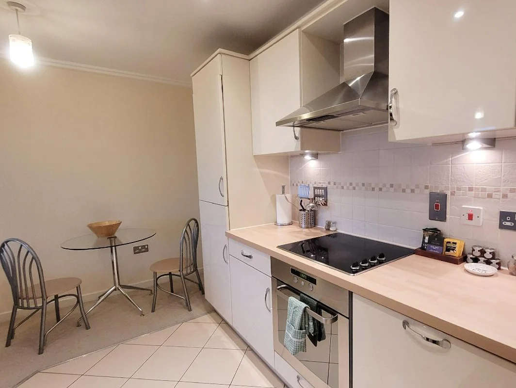 Fully equipped open-plan kitchen with oven, hob, and dining nook at The Elm Suite, Kings Road, Reading