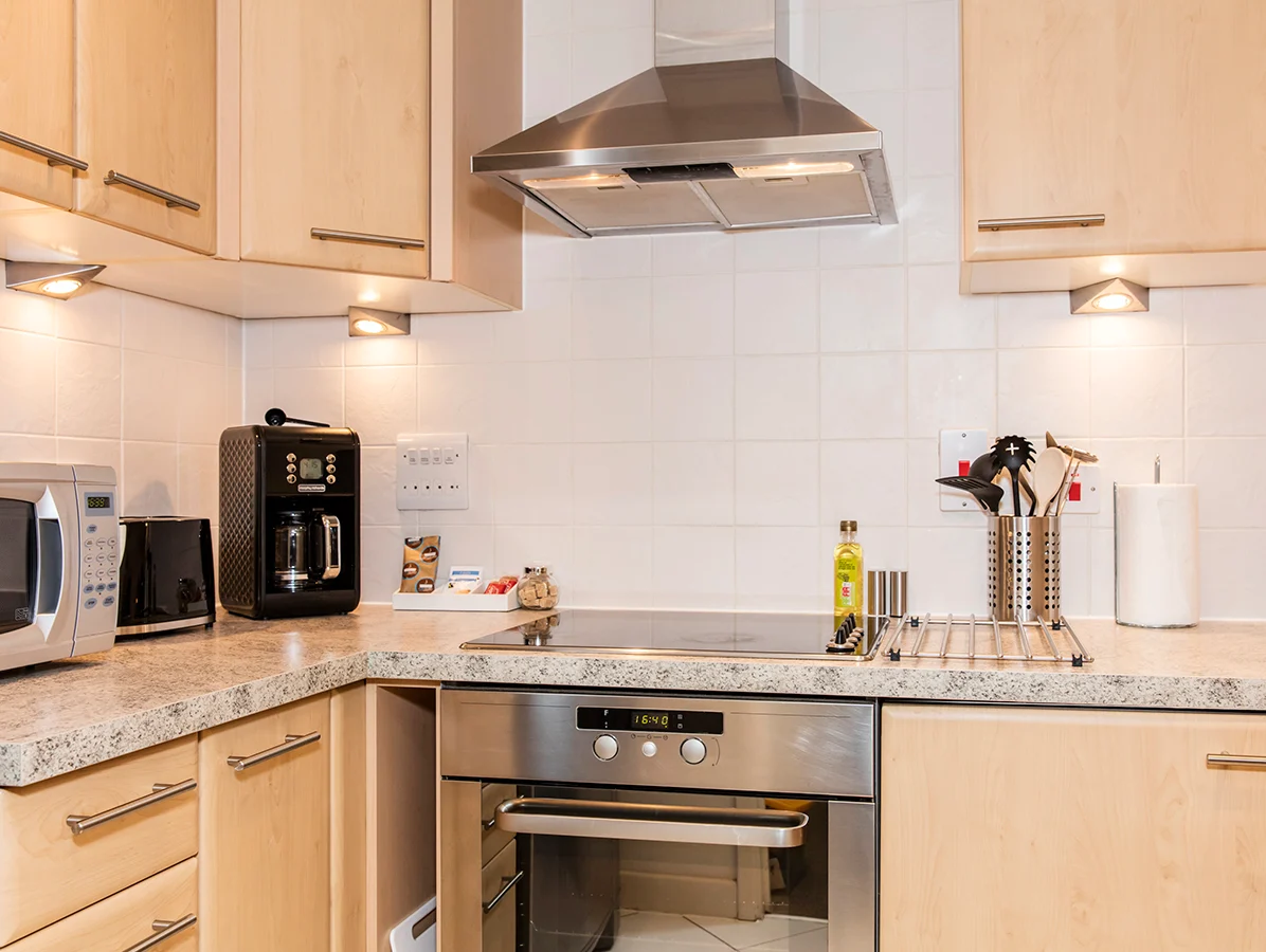 Fully fitted contemporary kitchen with integrated appliances and extractor fan at The Daisy Suite, Centrium, Woking