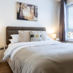 King bedroom with plush bedding, feature wall art, and city view at The Elm Suite, Kings Road, Reading