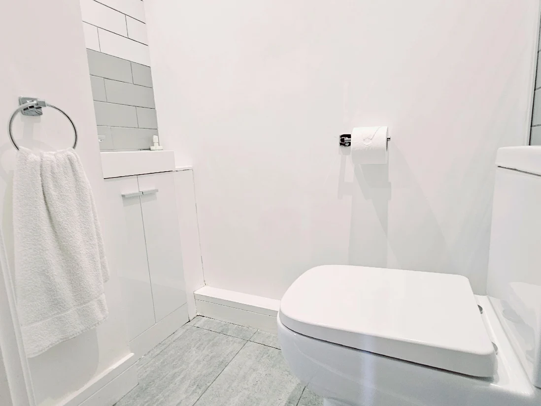Modern bathroom with overhead shower and white tiling at The Maple Suite, Oakdale Apartments, Farnham