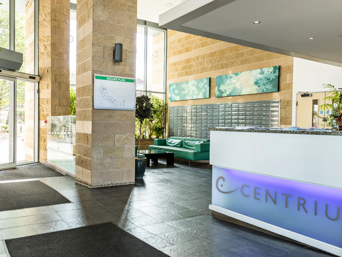 Reception area with Centrium signage and seating at modern apartment complex, Woking