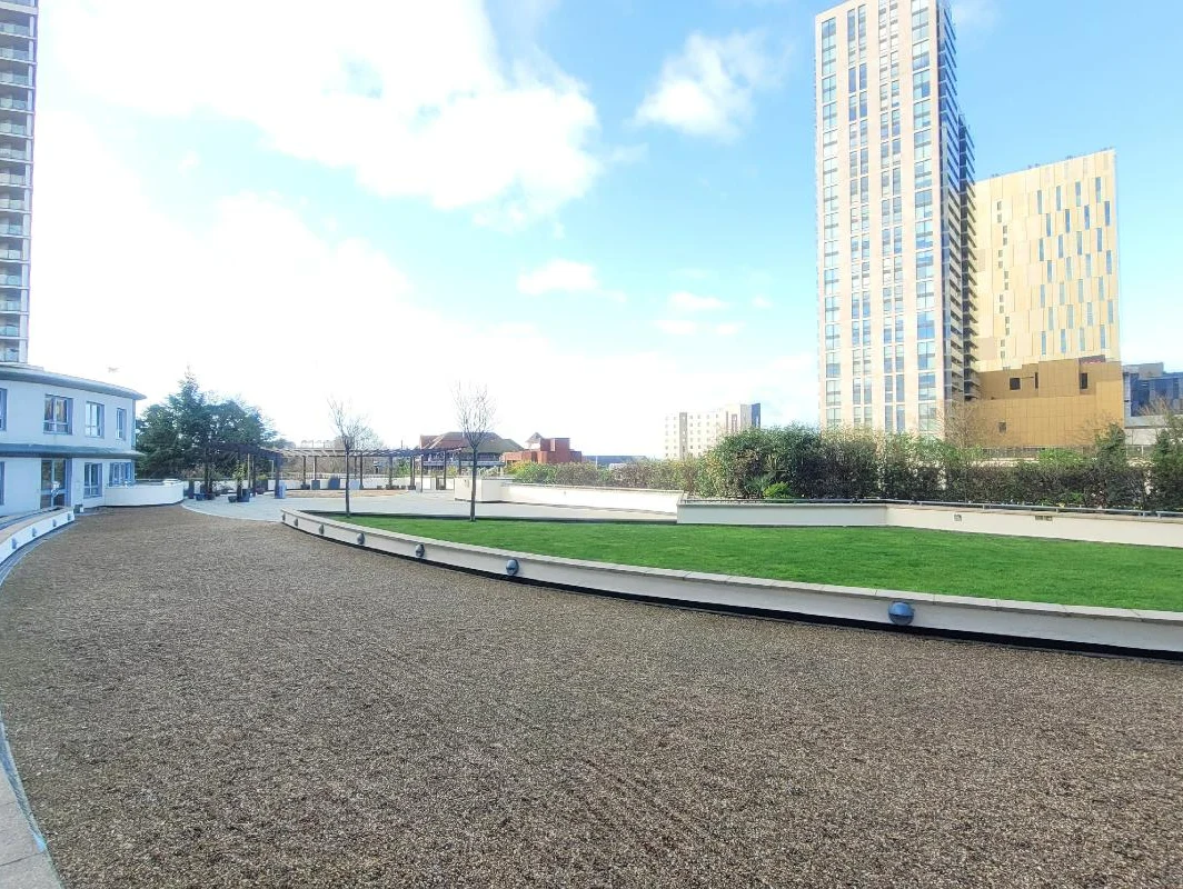 Sunny courtyard with landscaped pathways and garden at Kings Road apartments, Reading