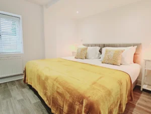 Spacious living room with dining area, modern furnishings, and a large window in The Oak Suite, Farnham