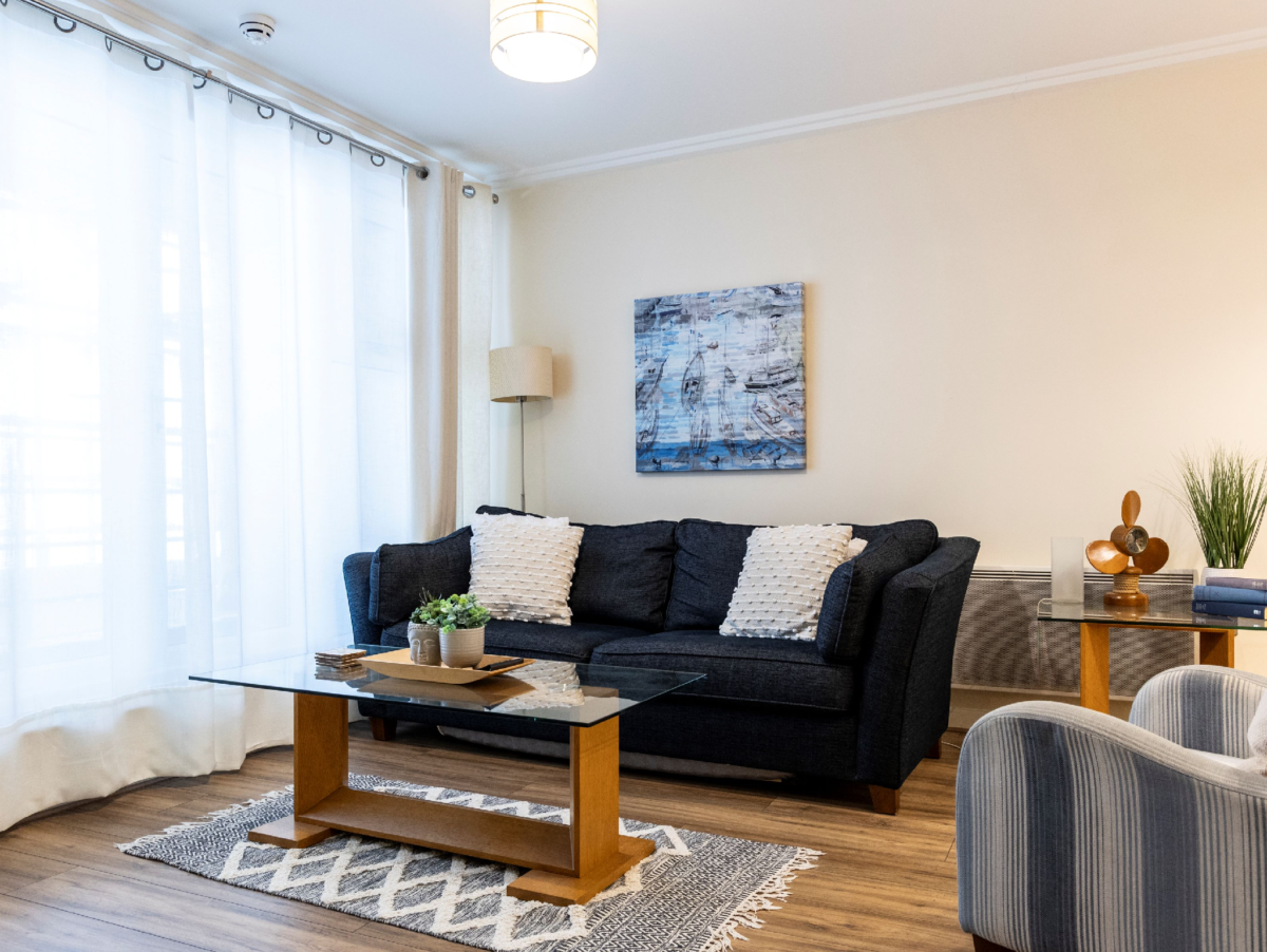 Bright living room with sofa, coffee table, and large windows at The Elm Suite, Kings Road, Reading