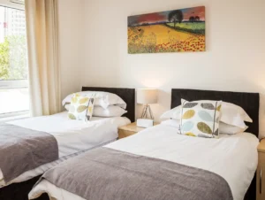 Bright twin bedroom with contemporary bedding and window view at The Amber Suite, Centrium, Woking