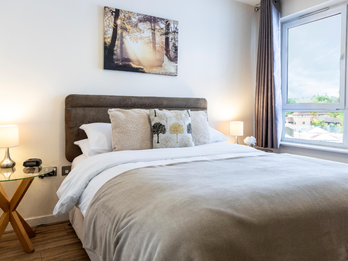 King bedroom with plush bedding, feature wall art, and city view at The Elm Suite, Kings Road, Reading